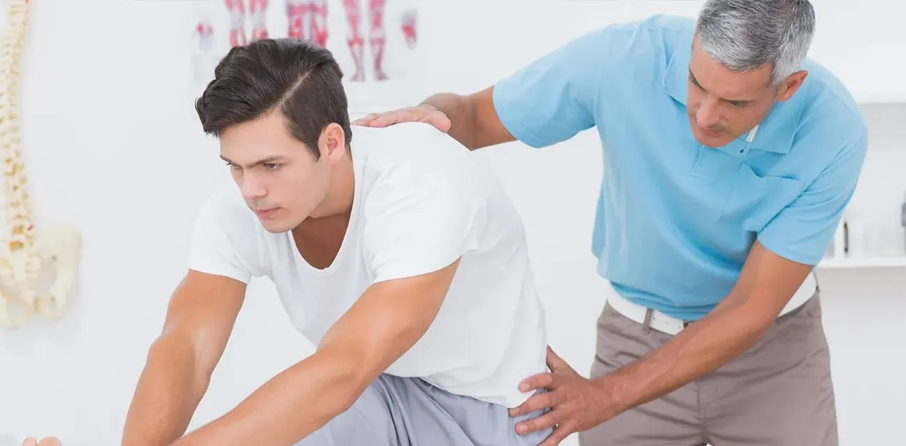 A chiropractor adjusting a patient&rsquo;s lower back