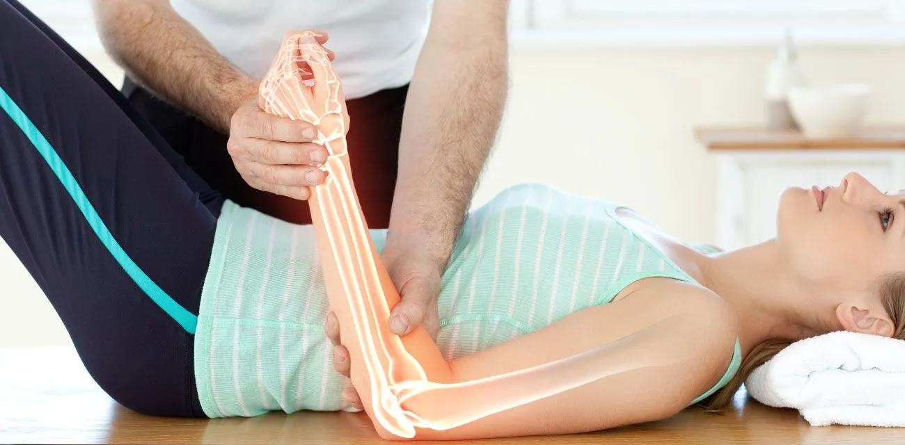 A chiropractor treating a patient&rsquo;s arm on a therapy table