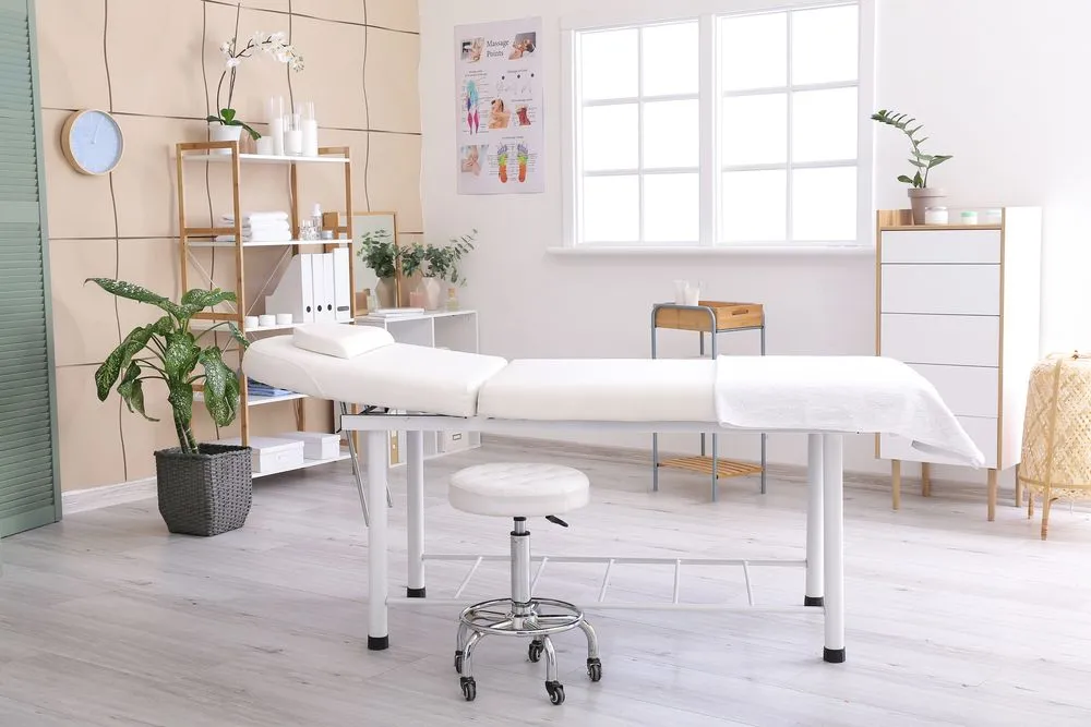 A bright private treatment room with an adjustment table
